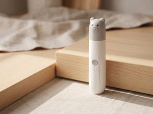 The Little One: a slim white grinder with a moulded grey bear-head cap